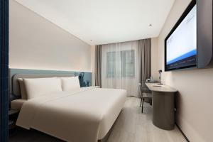 سرير أو أسرّة في غرفة في Atour Light Hotel Wuxi Taihu Lake Expo Center Financial Street
