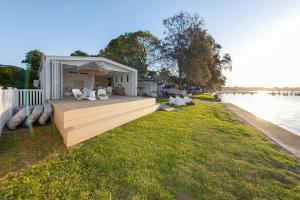 a house on the side of a river with a dock at The Boathouse in Bonnells Bay