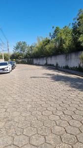 a cobblestone street with cars parked in a parking lot at WK Green Vine in Santa Rita do Sapucaí