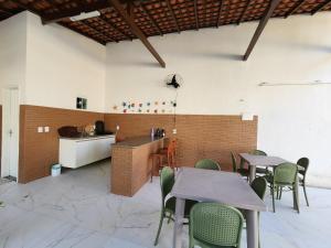 a restaurant with tables and chairs and a kitchen at Casa de Praia Araçagy in Macajatuba +8 photos