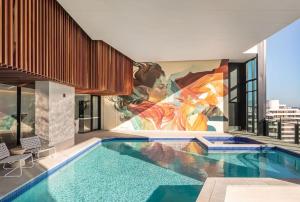 una piscina con murale sul lato di un edificio di Million dollar ocean view FREE Car park 3BR in Broadbeach, Australia a Gold Coast