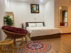 a bedroom with a bed and a chair and a rug at CHILL HOME 2 in Ho Chi Minh City +147 photos