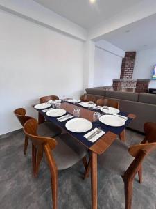 a dining room with a table and chairs and a couch at Villa Guerrero - Casa de Campo in Larán