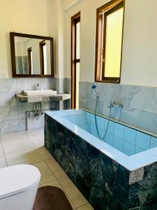 a bathroom with a tub and a toilet and a sink at Dream Mount Villa in Ella