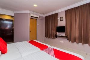 a bedroom with a white and red bed with a television at Golden Horse Hotel in Johor Bahru