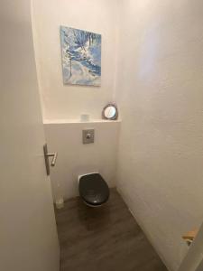 baño con aseo y asiento negro en Les platanes, en Béziers