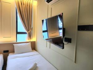 a room with a tv and a bed and a window at Georgetown AY Hotel in George Town