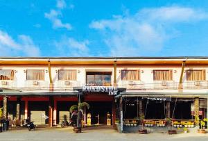 a large building with a building with windows and a motorcycle at Estancia Roadside Inn by RedDoorz in Estancia