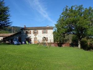 LaprugneにあるMaison de charme à la montagne avec animaux admis - FR-1-489-184の芝生の庭の前の古い石造りの家