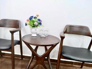 two chairs and a table with a vase of flowers at Ngọc Sơn Hotel in Hai Phong