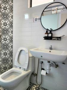 a bathroom with a toilet and a sink and a mirror at Georgetown AY Hotel in George Town