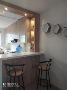 a kitchen with two bar stools in front of a counter at Apartamento Moderno Fonavi in Talara