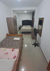 a small room with two beds and a mirror at Apartamento Moderno Fonavi in Talara +5 photos