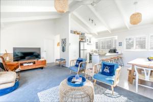een woonkamer met blauwe stoelen en een tafel bij Stylish Beach House Retreat - Close to River & Shops in Barwon Heads +24 foto's