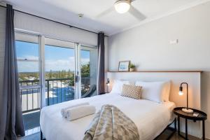 Un dormitorio con una cama grande y una ventana grande. en Yamba Views 10 - Oceanstays, en Yamba