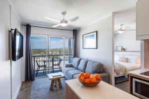 sala de estar con sofá y mesa con naranjas en Yamba Views 10 - Oceanstays, en Yamba