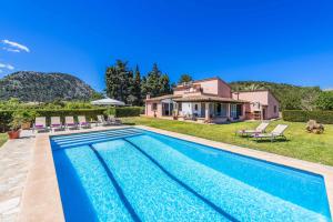 eine Villa mit Swimmingpool und ein Haus in der Unterkunft Can Patricia in Pollença
