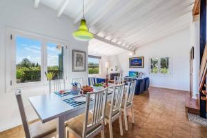 ein Esszimmer und ein Wohnzimmer mit Tisch und Stühlen in der Unterkunft Can Patricia in Pollença