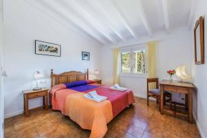 ein Schlafzimmer mit einem Bett, einem Tisch und einem Schreibtisch in der Unterkunft Can Patricia in Pollença