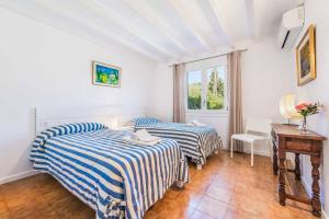 zwei Betten in einem Zimmer mit Tisch und Fenster in der Unterkunft Can Patricia in Pollença + 16 Fotos