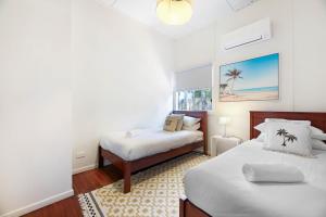 a bedroom with two beds and a window at 2-Bed Beach House in Burleigh Heads Amidst Nature in Gold Coast