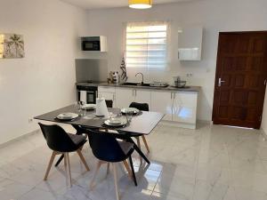 a kitchen with a table and chairs in a kitchen at Villa Ébène in Cabassou