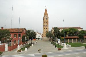 a church steeple with a clock tower in a town at Appartamento Ai Tigli in Caorle