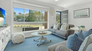 ein Wohnzimmer mit Sofa und Tisch in der Unterkunft Woodhill Cottage in Worrowing Heights