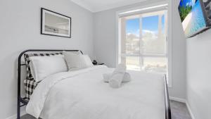 ein weißes Schlafzimmer mit einem weißen Bett und einem Fenster in der Unterkunft Woodhill Cottage in Worrowing Heights