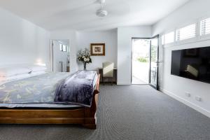 a bedroom with a bed and a flat screen tv at Karri Keep - Spacious 3 Bedroom Town Villa in Margaret River Town