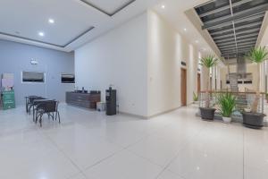 an empty lobby with tables and chairs in a building at Urbanview Darmo Residence Bandung in Bandung