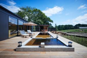 a backyard with a pool and an umbrella at SONEKA in Kitahiroshima
