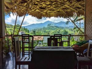 a restaurant with a table and chairs and a view of mountains at Dream Mount Villa in Ella