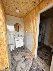 an unfinished bathroom with a sink and a toilet at Lake_glamping_ik in Tossor