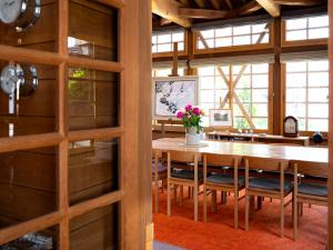 a dining room with a wooden table and chairs at Kihachikan North Nozawa Onsen in Nozawa Onsen