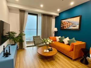 a living room with an orange couch and a blue wall at Sea Gallery Phu Quoc Luxury Apartment in Phu Quoc