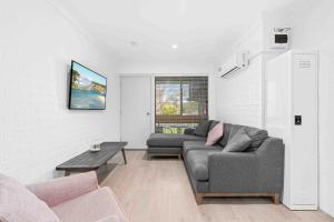 a living room with a couch and a table at 2 Cute by Experience Jervis Bay in Huskisson