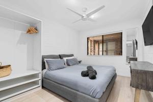 a bedroom with a large bed with a ceiling fan at 2 Cute by Experience Jervis Bay in Huskisson