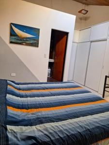 a bed in a room with a painting on the wall at Espacioso dúplex, ubicación premium in San Luis
