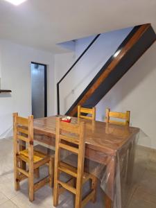 a wooden dining room table with chairs and a staircase at Espacioso dúplex, ubicación premium in San Luis