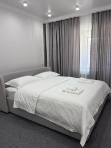 a bedroom with a bed with two towels on it at Juldyz in Zharkent