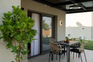 a dining room table and chairs on a patio at Olympus Mare Village Seaside Pool Villas in Katerini