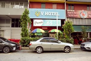 a silver car parked in a parking lot in front of a building at V Hotel Titiwangsa in Kuala Lumpur