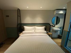 a large white bed in a room with a mirror at Luxeur Jakarta - Setiabudi in Jakarta