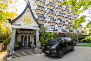 een auto geparkeerd voor een gebouw bij Two Seasons Siem Reap Hotel in Siem Reap