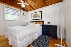 een slaapkamer met een groot bed en een raam bij Beachfront Cottage #2- Maijac Resort & Marina in Burks Falls +21 foto's