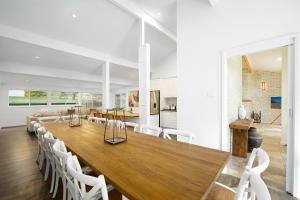 une salle à manger avec une grande table en bois et des chaises blanches dans l'établissement Acreage Estate -Mini Horses -Outdoor Spa -Tennis Court, à Holgate