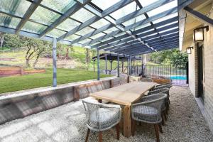 un patio extérieur avec une table et des chaises en bois dans l'établissement Acreage Estate -Mini Horses -Outdoor Spa -Tennis Court, à Holgate 13 autres photos