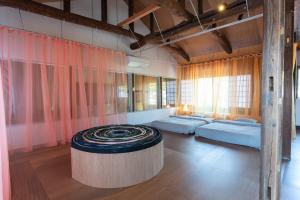 a room with four beds and a table in it at SEW STAY Soft Seam KYOTO MAIZURU in Maizuru