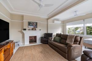 阿勒达拉Fish Cottage Ulladulla - Linen not supplied - 3 bedroom house - sleeps 8 - pet friendly的带沙发和壁炉的客厅